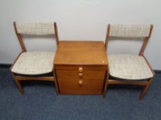 A 20th century teak two drawer bedside chest with slide together with a pair of 20th century teak
