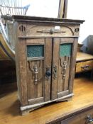 An Edwardian oak Arts and Crafts miniature double door cabinet,
