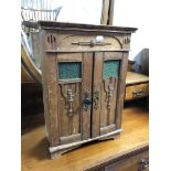 An Edwardian oak Arts and Crafts miniature double door cabinet,