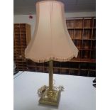 A brass Corinthian column table lamp with shade