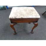 An Edwardian mahogany storage piano stool on claw and ball feet