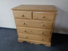 A stripped pine five drawer chest
