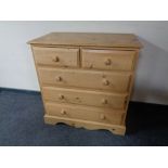 A stripped pine five drawer chest