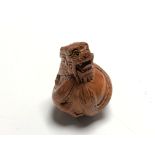 A carved Chinese hardwood netsuke - Dragon holding an egg