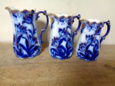 A set of three antique blue and white gilded jugs