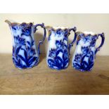 A set of three antique blue and white gilded jugs