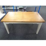 A contemporary pine topped extending dining table on painted legs