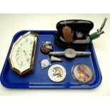 A tray containing a vintage Rhythm gas iron, car badges, Italian pin badge,