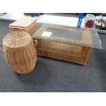 A wicker glass topped conservatory table together with two wicker laundry baskets