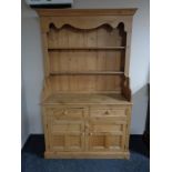 A stripped pine welsh dresser fitted double door cupboard and two drawers beneath