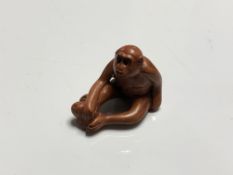 A carved Chinese hardwood netsuke - Monkey with fruit