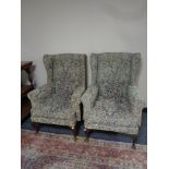 A pair of tapestry upholstered wingback armchairs on Queen Anne legs