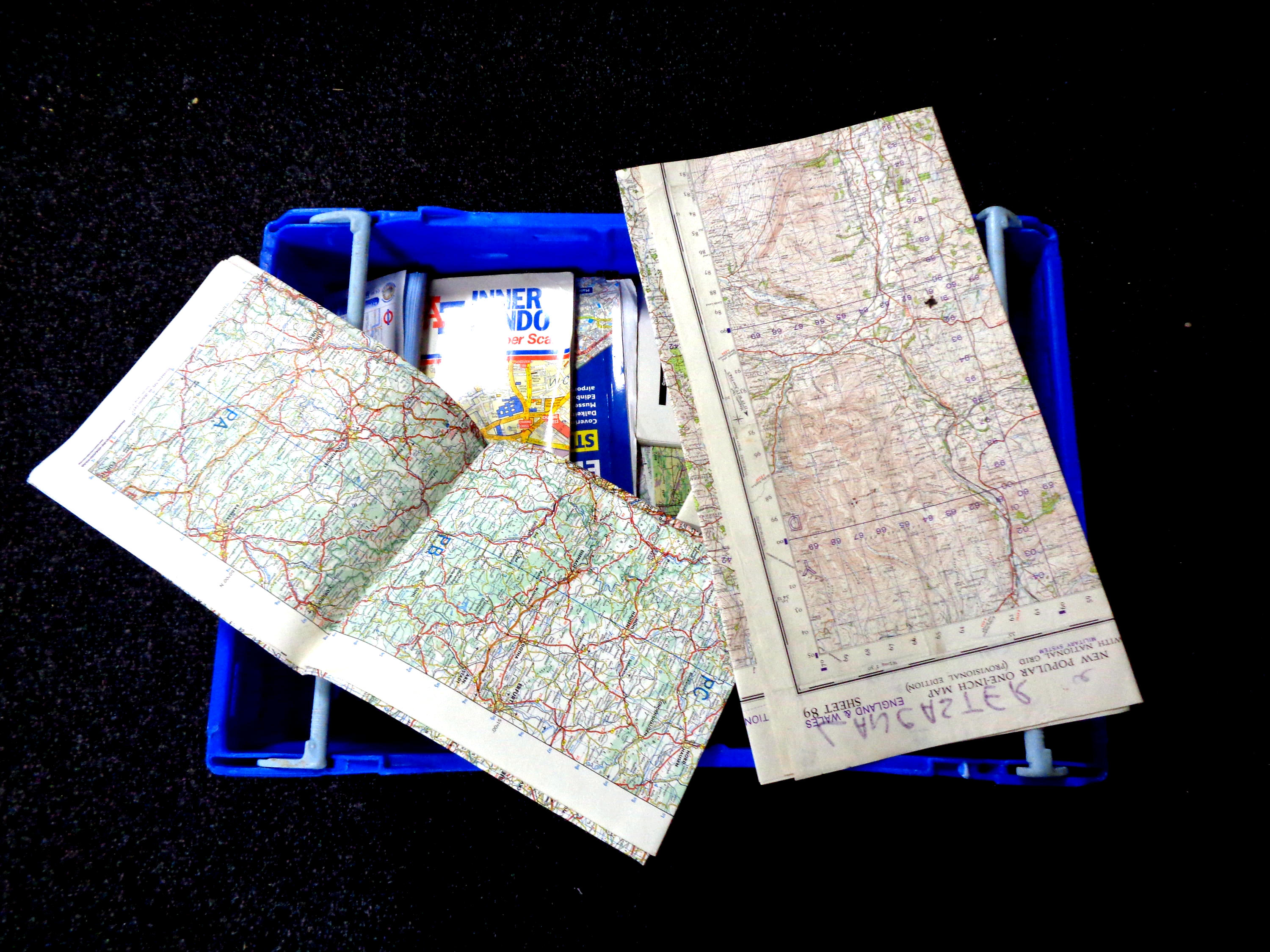 A box containing a large quantity of assorted road maps