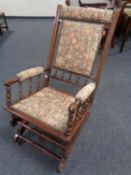 A stained beech rocking chair in tapestry upholstery