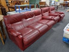 A Burgundy leather three piece lounge suite comprising pair of armchairs and three seater settee