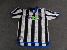A vintage Newcastle United football shirt bearing many signatures including Sir Bobby Robson,