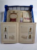 A basket containing a collection of cigarette cards in albums and a framed set of cigarette cards