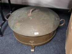 A large circular copper lidded cooking pot