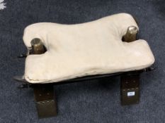 A brass mounted camel stool with leather seat