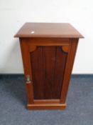 A mahogany single door cabinet together with a small painted stool and a wicker and metal three