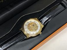 A gent's Stuhrling gold plated automatic wristwatch with visible movement, boxed.