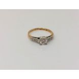 An antique 18ct gold diamond solitaire ring with diamond set shoulders,