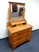 An Edwardian satin wood three drawer dressing chest with mirror back