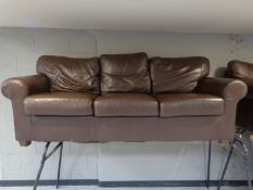 A pair of brown leather three seater settees