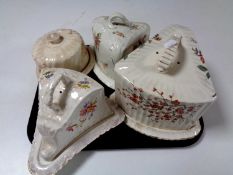 A tray of four antique pottery cheese dishes and covers