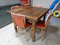An early twentieth century oak pull out dining table together with a set of four chairs