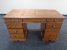 A contemporary pine computer desk fitted nine drawers