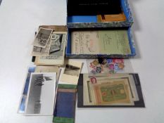 A box containing loose German Third Reich stamps and bank notes, military postcards,