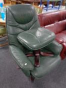 A green leather swivel armchair with matching footstool on rosewood effect base