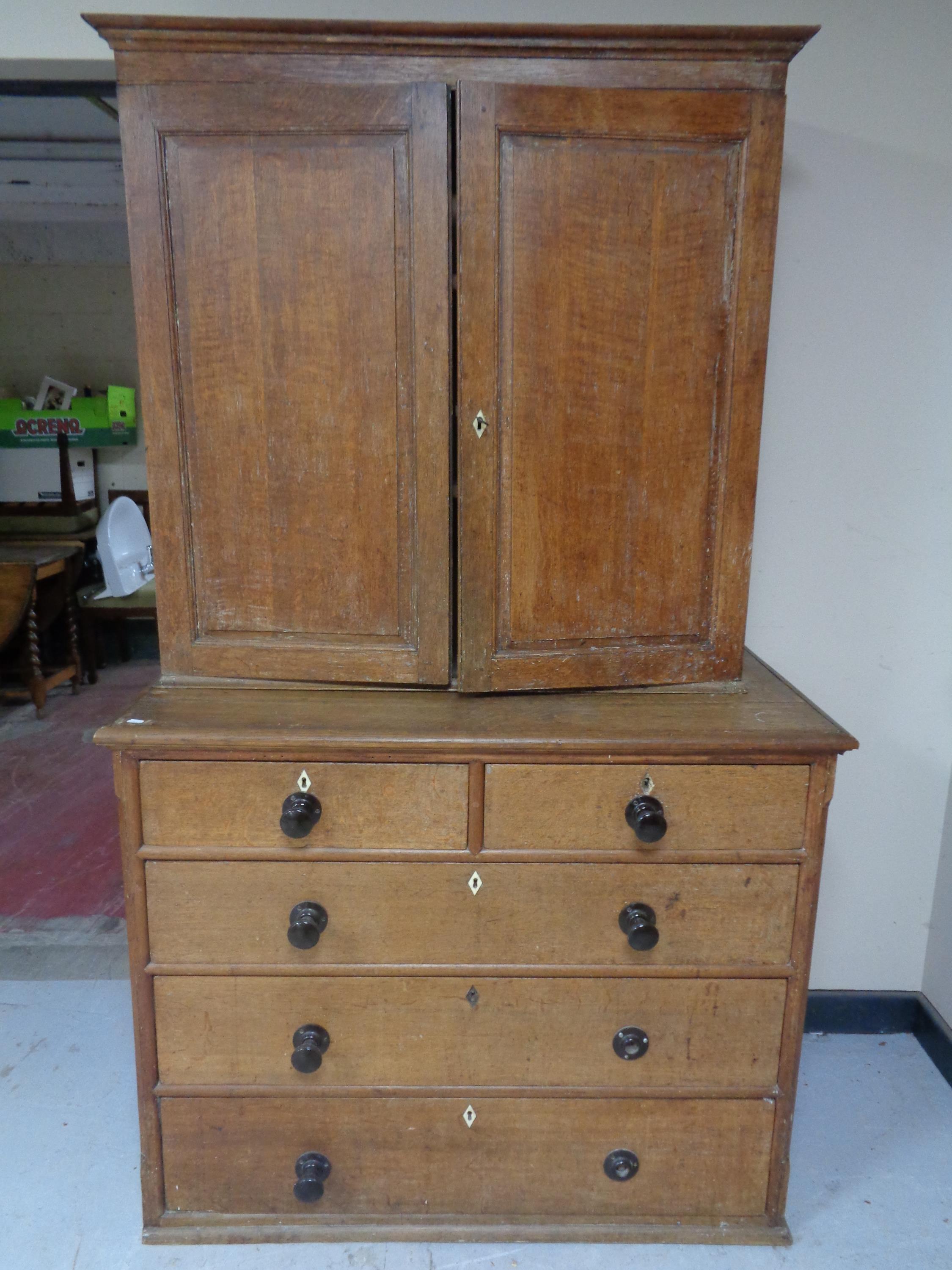 A 19th century oak double door cabinet on five drawer chest