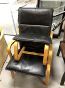 A Stouby beech framed black leather armchair with matching footstool