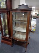 An Edwardian inlaid mahogany bow fronted display cabinet with leaded glass doors