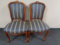 A pair of continental carved salon chairs on cabriole legs in fleur de lys upholstery