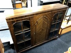 An early 20th century mahogany triple door bookcase with central panel door and glass doors either