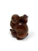 A carved Chinese hardwood netsuke - Rabbit family