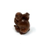 A carved Chinese hardwood netsuke - Rabbit family