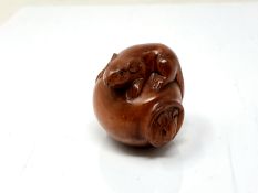 A carved Chinese hardwood netsuke - Rat climbing on a pot