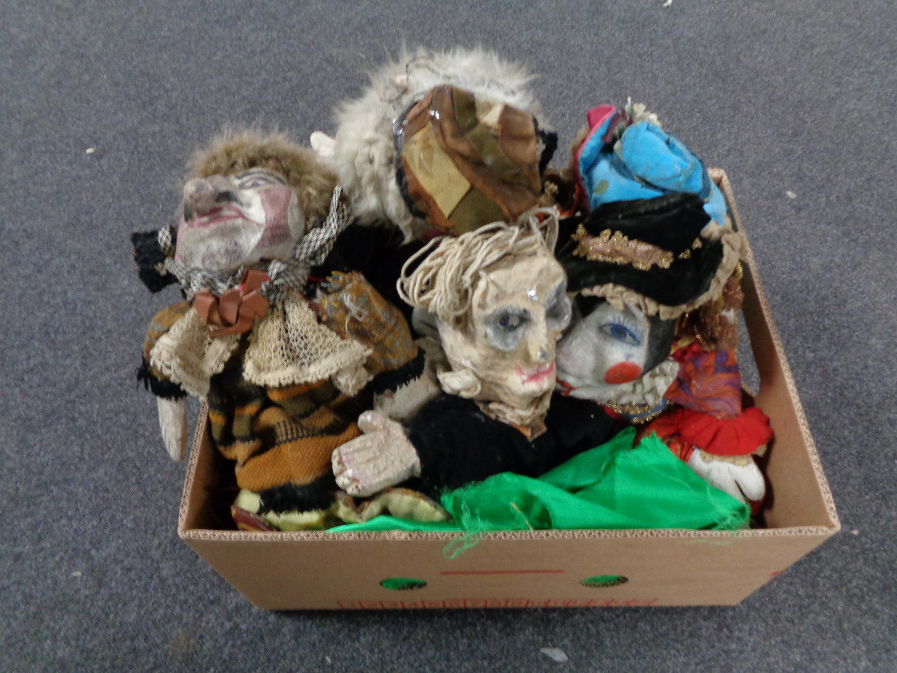 A box containing six papier mache theatre hand puppets