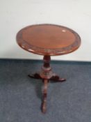 A carved hardwood tripod occasional table
