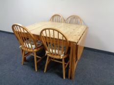 A pine drop leaf extending dining table and four spindle backed chairs