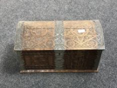 A heavily carved metal bound dome top miniature blanket box