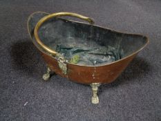 A Victorian brass and copper swing handled coal bucket on paw feet