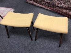 A pair of twentieth century teak footstools in yellow upholstery