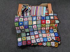 A box containing three colourful woolen throws together with a further bed throw depicting dogs