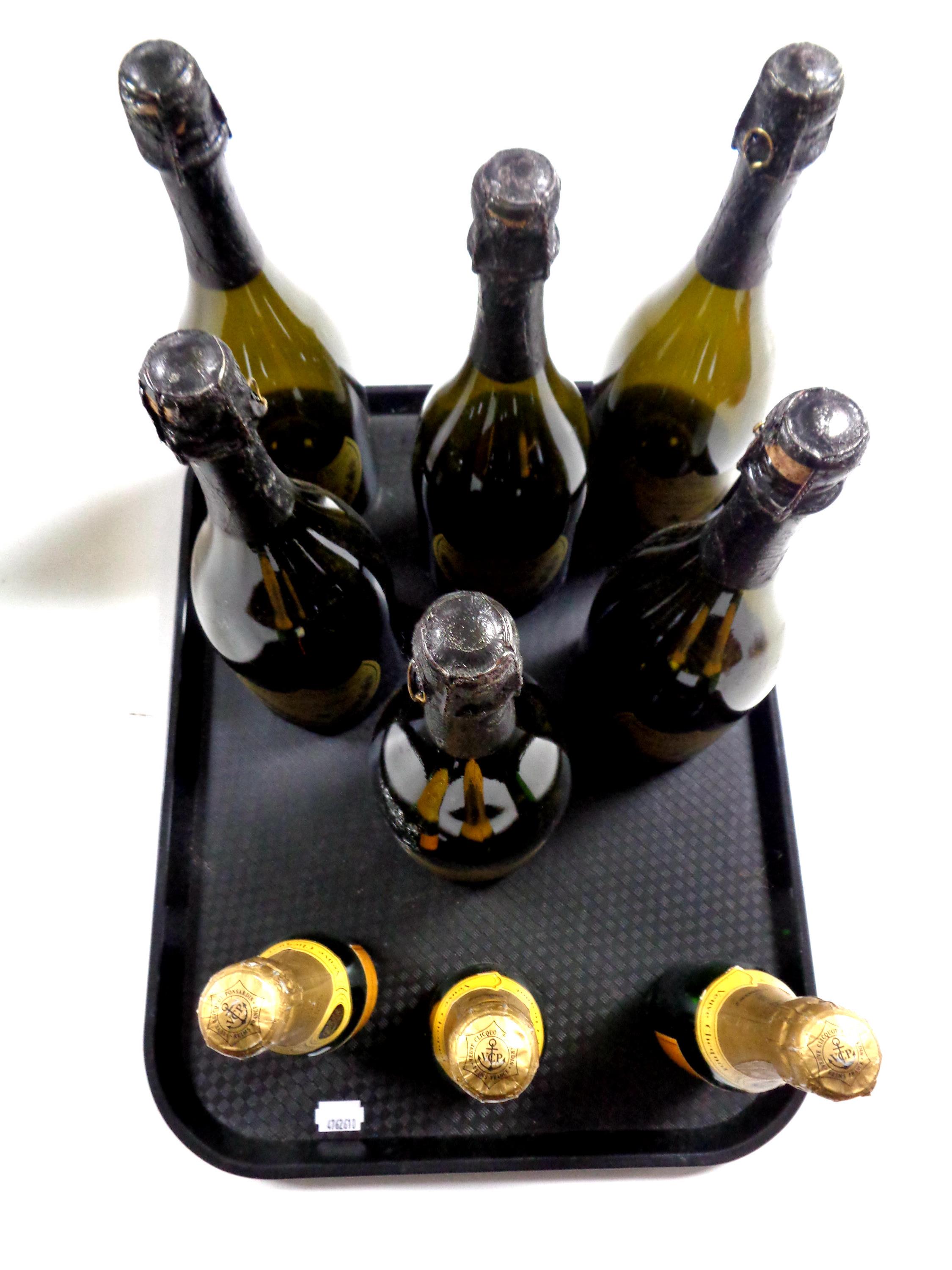 A tray of six empty display bottles of Dom Perignon Champagne and three similar bottles of Veuve