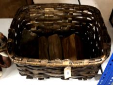 A woven log basket containing a small quantity of logs